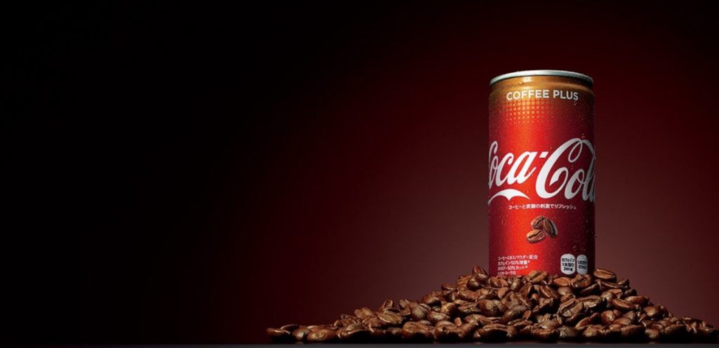 È in arrivo in Italia Coca Cola Plus Coffee, un nuovo prodotto del marchio Coca Cola che sancisce l’ingresso del gigante delle bollicine nel mercato delle bevande energetiche. Coca Cola Plus Coffee è stato commercializzato per la prima volta in Australia nel 2017. Secondo Cocacolaitalia, il prodotto è già acquistabile in Spagna, Turchia e Vietnam. Ma è il Giappone a costituire il principale mercato per quanto riguarda questo prodotto. In Italia, secondo alcune indiscrezioni, Coca Cola Plus Coffee potrebbe essere reperibile nei supermercati già a fine mese. L’energy drink sarà prodotto direttamente in Italia, negli stabilimenti Coca Cola di Nogara (VR) e di Marcianise (CE). Secondo Wired, Coca Cola punta a espandere sempre più il suo dominio nel mondo delle bevande energizzanti, con l’obbiettivo di raggiungere entro fine anno più di 25 mercati in tutto il mondo. Coca Cola Plus Coffee è una variante della celebre bevanda analcolica, come lo sono per esempio Coca Cola gusto limone o Coca Cola gusto vaniglia. A differenza della Coca Cola classica però, essa è caratterizzata dall’aggiunta di un aroma al caffè e dall’assenza di zucchero. Ma non è tutto: la quantità di caffeina presente al suo interno risulta maggiore rispetto ad una Cola semplice. In una lattina da 250 ml sono presenti 40 mg di caffeina, l’equivalente di una tazzina di caffè. Con questo prodotto quindi The Coca Cola Company ha debuttato ufficialmente nel mercato degli Energy Drink.