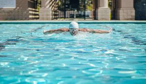 Uomo che nuota in una piscina